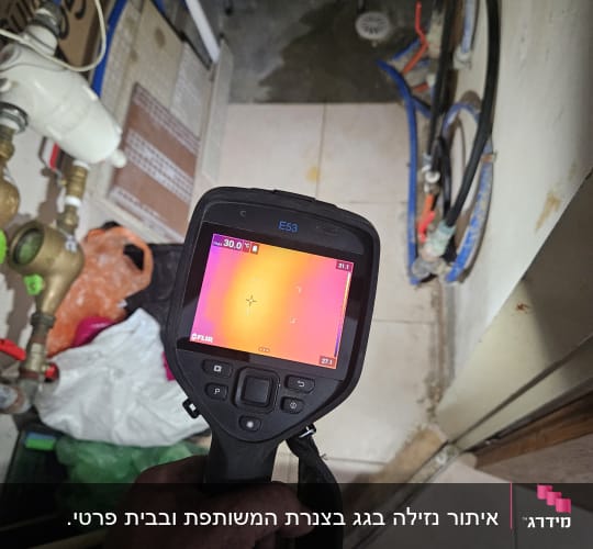 אדם מחזיק מצלמה תרמית לבדיקת נזילות מים